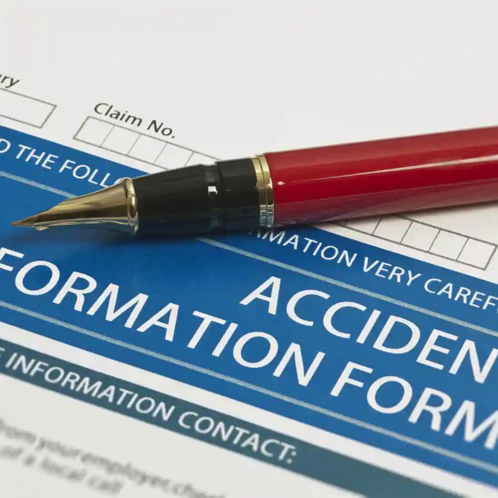 Red pen sitting on top of an accident form