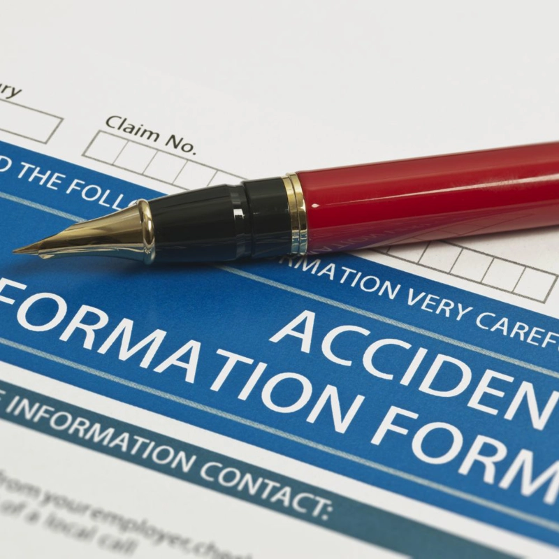 Red pen sitting on top of an accident form