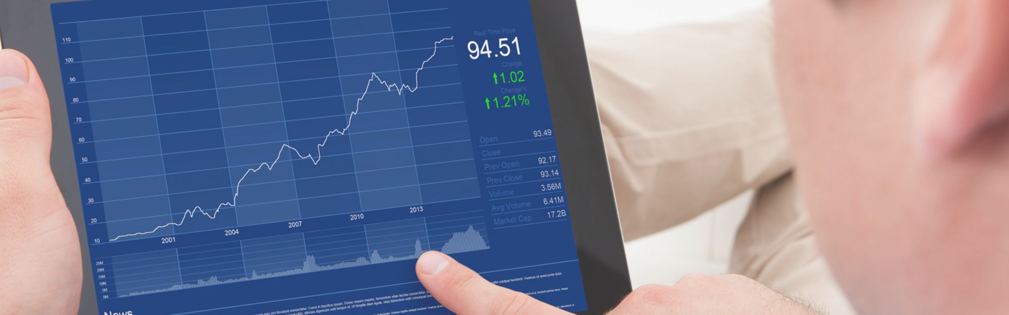 man looking at upward graph on a tablet